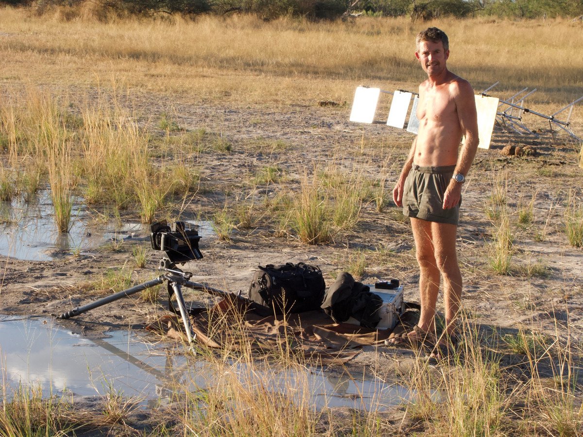 Koos van der Lende in a wetland beside his tripod and white reflector boards